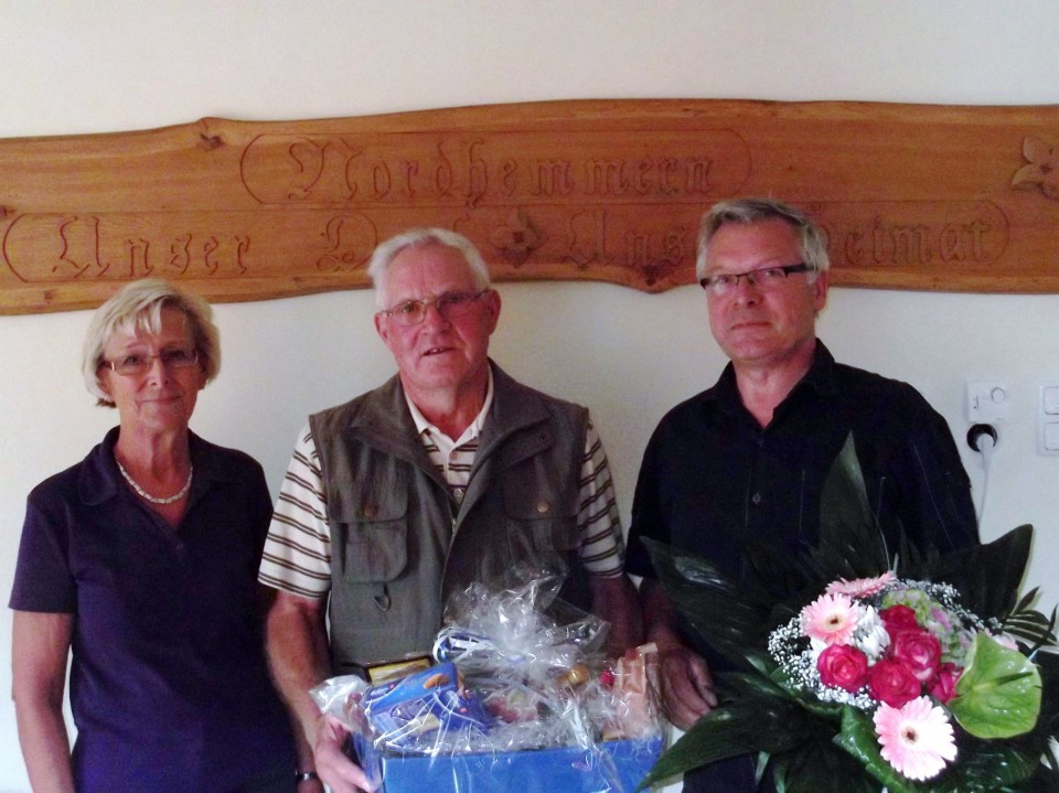 Liane Spilker und Hartmut Borcherding berreichen Prsentkorb und Blumenstrau an Wilhelm von Behren (Bildmitte)